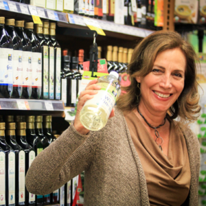 Beth Greer, aka The Super Natural Mom®, holding a bottle of white vinegar